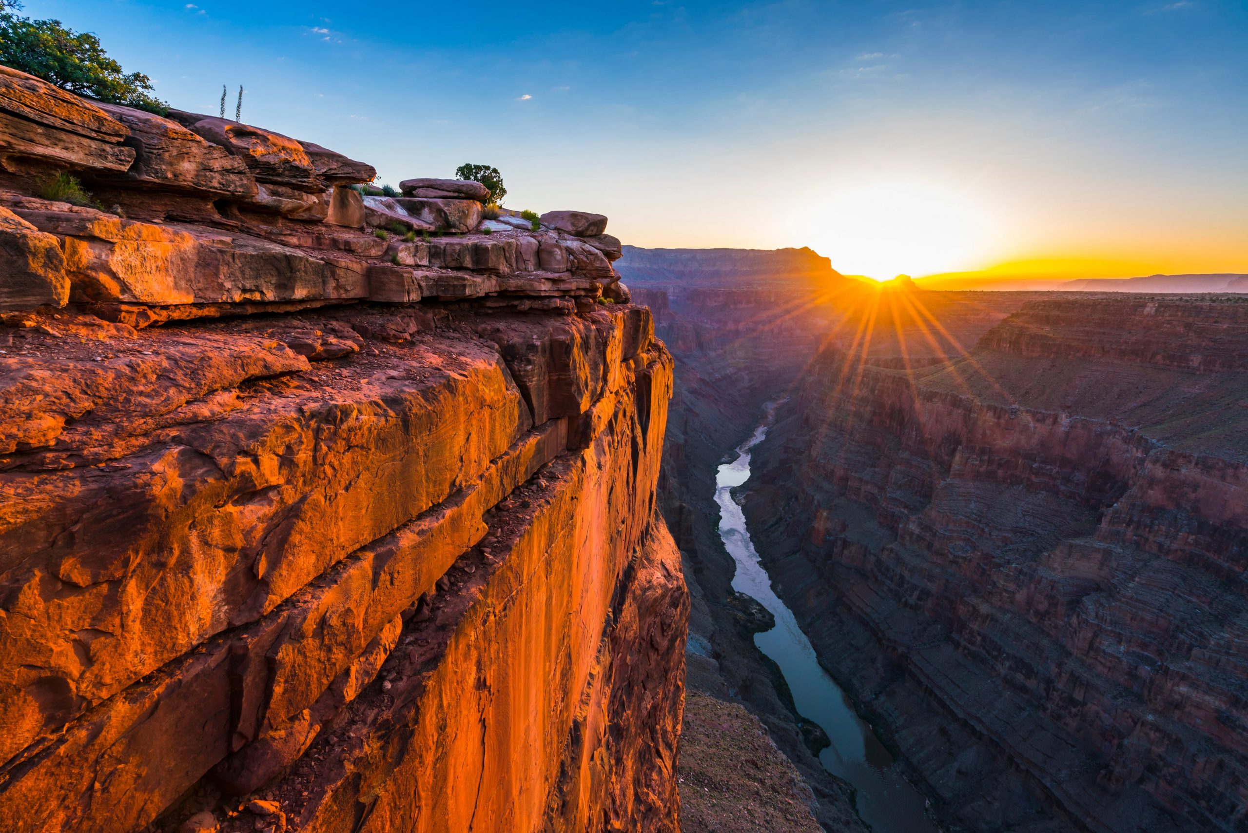 A view of the sunrise over the Grand Canyon with the Colorado River below.